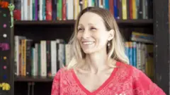 Alison Entrekin posa em frente à sua estante de livros