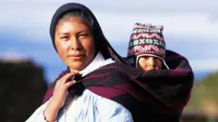 Una mujer con un niño en la espalda