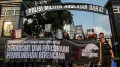 Številni aktivisti razgrnejo plakate in transparente med solidarnostno akcijo za Andrieja Yunusa pred poveljstvom vojaške policije vojske v Džakarti v četrtek (16. 4. 2026). Zahtevali so, da se sojenje v primeru polivanja Andrija Yunusa s kislino izvede na civilnem sodišču.