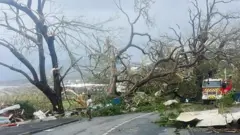 The roads are littered with debris from trees and homes
