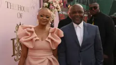 پیتسو موسیمانه همراه با مویرا، همسر و مدیر برنامه‌هایش