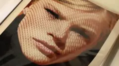 Picture in an album showing an artistic headshot of a young blonde woman looking into the camera.