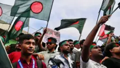 Demonstrators wave Bangladesh's national flag during Martyr March, a rally organised by Students Against Discrimination to mark one month to the ousting of the country's former Prime Minister Sheikh Hasina, in Dhaka on September 5, 2024. Bangladesh's ousted premier Sheikh Hasina should "keep quiet" while exiled in India until she is brought home for trial, interim leader Muhammad Yunus told Indian media on September 5. Hasina, 76, fled to India by helicopter one month ago as protesters marched on her palace in a dramatic end to her iron-fisted rule of 15 years. (Photo by Munir UZ ZAMAN / AFP) (Photo by MUNIR UZ ZAMAN/Demonstrators wave Bangladesh's national flag during Martyr March, a rally organised by Students Against Discrimination to mark one month to the ousting of the country's former Prime Minister Sheikh Hasina, in Dhaka on September 5, 2024. Bangladesh's ousted premier Sheikh Hasina should "keep quiet" while exiled in India until she is brought home for trial, interim leader Muhammad Yunus told Indian media on September 5. Hasina, 76, fled to India by helicopter one month ago as protesters marched on her palace in a dramatic end to her iron-fisted rule of 15 years. (Photo by Munir UZ ZAMAN / AFP) (Photo by MUNIR UZ ZAMAN/AFP via Getty Images))