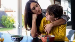 Mão abraçando e conversando com o filho