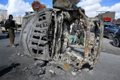 एक फरवरी, 2026 को क्वेटा के बाहरी इलाके में एक सड़क के किनारे जले हुए वाहन के पास से लोग गुज़र रहे हैं. 