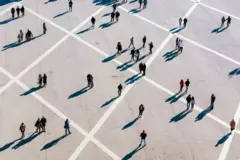 Personas caminando y proyectando sombras en piso cuadriculado