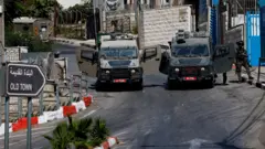 يقف أفراد من القوات الإسرائيلية بالقرب من مركبات عسكرية أثناء مداهمة إسرائيلية في رام الله، في الضفة الغربية المحتلة.