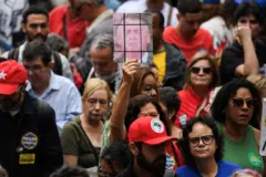 Um manifestante segura uma placa com a imagem do ex-presidente brasileiro Jair Bolsonaro atrás de grades, durante uma manifestação contra o ex-presidente, no Rio de Janeiro, m 7 de setembro de 2025.