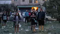 Місцеві жителі спостерігають, як рятувальники проводять пошуково-рятувальні операції. Київ, Україна, 6 липня 2026 року. Фото ілюстративне
