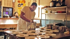 Dans la cuisine de son restaurant, le chef Ayo Balogun, mains dans une grande marmite, s'apprête à dresser une dixaine d'assiettes installée sur une table.