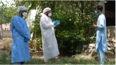 کارکنان بهداشتی در صحبت با مردی در روستا