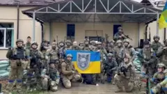 Украин аскерлери Харьковдун түндүк-чыгышындагы Россиядан бошотуп алган кыштакта желек көтөрүп сүрөткө түшүүдө.