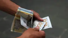 يظهر مواطنون إيرانيون في صورة التُقطت في 4 مايو/أيار 2026 في طهران، إيران، بينما يسجل الدولار الأمريكي أعلى مستوى له على الإطلاق في السوق المفتوحة، في حين تستمر العملة الوطنية في الانخفاض الحاد تحت وطأة العقوبات الأمريكية المشددة والضغوط الاقتصادية الناجمة عن الحرب