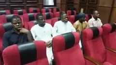 Foto of di five suspects as dem sidon for chair, one wear black shirt, di two for middle wear clothes wey resemble while di oda one wear cloth wey resemble light brown while di last one wear T-shirt wey resemble pink wey don fade.