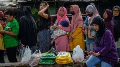 Warga antre untuk membeli beras medium saat operasi pasar murah di Taman Film, Bandung, Jawa Barat, Senin (19/2/2024).