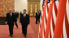 Çin Devlet Başkanı Şi Jinping (sağda) ve ABD Başkanı Donald Trump, 14 Mayıs 2026 tarihinde Pekin'deki Halkın Büyük Salonu'nda düzenlenecek devlet resepsiyonuna katılmak üzere salona giriş yapıyor.