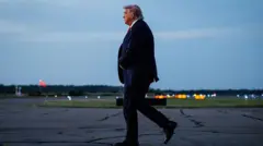 Donald Trump após descer de seu avião, andando na pista de um aeroporto