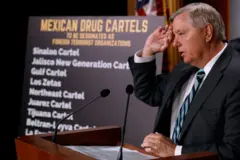 O senador Lindsey Graham ao lado de um cartaz que menciona cartéis mexicanos.