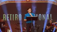 Padre Reginaldo Manzotti no palco durante retiro