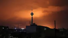 Torre vista em meio a um céu alaranjado