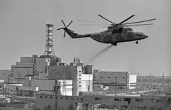 Uma foto de arquivo em preto e branco mostra um helicóptero espalhando componentes de descontaminação sobre a área contaminada da Usina Nuclear de Chernobyl