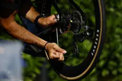 عکس چرخ جلوی دوچرخه که کسی در حال تنظیم آن است