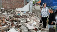 Elina Widjajanti (pakaian hitam) didampingi Maria Sudarsini saat melihat rumahnya sudah rata dengan tanah.