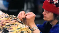 Judith Scott, concentrada, trabajando