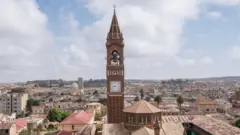 ካቴድራለ ካቶሊካዊት ቤተክርስትያን ዘገረማ ርእሰከተማ ኣስመራ ሰማያታ ጻዕዳ ደበና ለቢሱ ይርአ