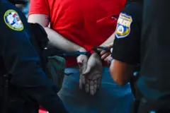 Hombre de espaldas esposado