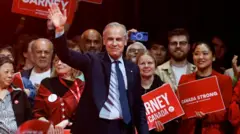 自由党の勝利が確実になり、同党本部で支持者らを前に笑顔で手を振るマーク・カーニー首相（29日、オタワ）