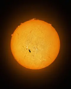 Imagen completa de la silueta de un hombre en negro y el sol, con sus llamas, de fondo