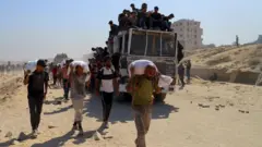 فلسطينيون يحملون مساعدات.