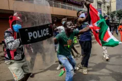 Des manifestants en colère brandissent un bouclier de police et un drapeau kenyan, scandant des slogans (Ruto doit partir) lors d'une manifestation contre les meurtres commis par la police sur des personnes qui protestaient contre le projet de loi anti-fiscalité au Kenya, le 2 juillet 2024 à Nairobi, au Kenya.