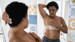 Une femme se regardant dans le miroir.