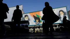 جدارية تضم صورا للمرشد الأعلى الإيراني علي خامنئي وقائد الثورة الإسلامية الإيرانية عام 1979 الخميني، في أحد شوارع طهران