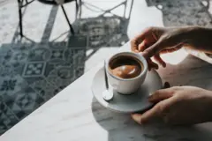 Close em uma mão segurando uma xícara de café