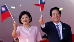 台北總統府前國慶大會上台灣總統賴清德（右）與夫人吳玫如（左）揮舞青天白日滿地紅小旗（10/10/2025）