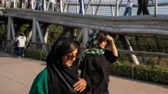 Две иранки идут вдоль моста в Тегеране