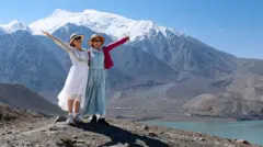 Two women posing for a picture at White Sand Lake in Xinjiang's Akto County