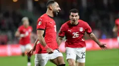 يحتفل محمد صلاح مع أحمد مصطفى بعد تسجيله هدف الفوز 3-1 خلال مباراة دور الـ16 من بطولة كأس الأمم الأفريقية 2025 بين مصر وبنين في أغادير، المغرب، 5 يناير 2026.