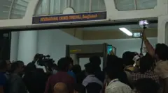 আন্তর্জাতিক অপরাধ ট্রাইব্যুনালের গেটের সামনে মানুষের ভিড়, কয়েকজন মোবাইল ও ক্যামেরা তাক করে আছেন গেটের দিকে