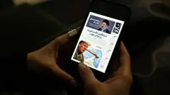 شاشة هاتف تحتوي صفحة من صحيفة إيرانية عليها صورتين واحدة للمرشد الإيراني الأعلى الجديد والأخرى للرئيس الأمريكي دونالد ترامب