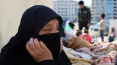 Displaced people sit beneath a statue at Martyrs' Square in Beirut, Lebanon (3 March 2026)