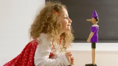 Uma menina em frente a um boneco do Pinóquio de madeira
