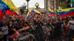 Multidão reunida com bandeiras da Venezuela, em claro ambiente festivo em Santiago do Chile