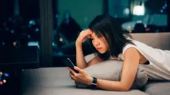 Una mujer asiática consulta su móvil