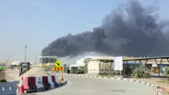 Над портом Джебель-Али поднимается дым после иранской атаки, последовавшей за ударами США и Израиля по Ирану, в Дубае, Объединенные Арабские Эмираты, 1 марта 2026 г.