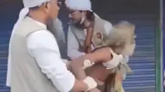 একজন বৃদ্ধ লোককে জোর করে আটকে রাখার চেষ্টা করছেন পাঞ্জাবি ও পাগড়ি পরা দুই লোক