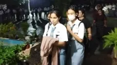 Para siswi kelas XII di SMAN 6 Kupang berbaris menuju kelas usai apel di tengah lapangan yang gelap, Selasa (28/02).